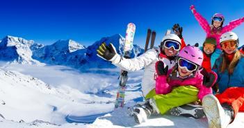 Comment réussir ses vacances au ski ? Famille heureuse en station de ski