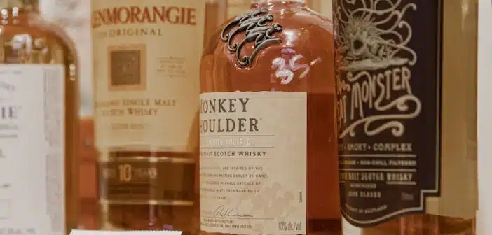 four bottles on brown wooden shelf