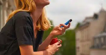 a woman holding a cup and a cell phone