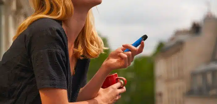 a woman holding a cup and a cell phone
